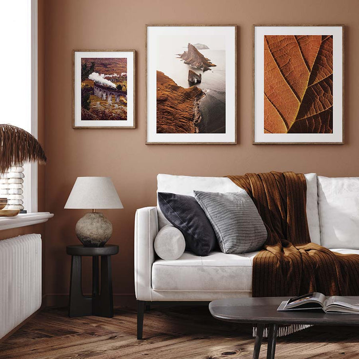 Herbstliche Bilderwand in einem braunen Wohnzimmer