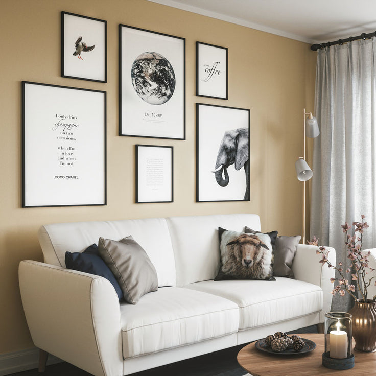 Bilderwand auf gelb gefärbten Wand über weißen Sofa im Wohnzimmer