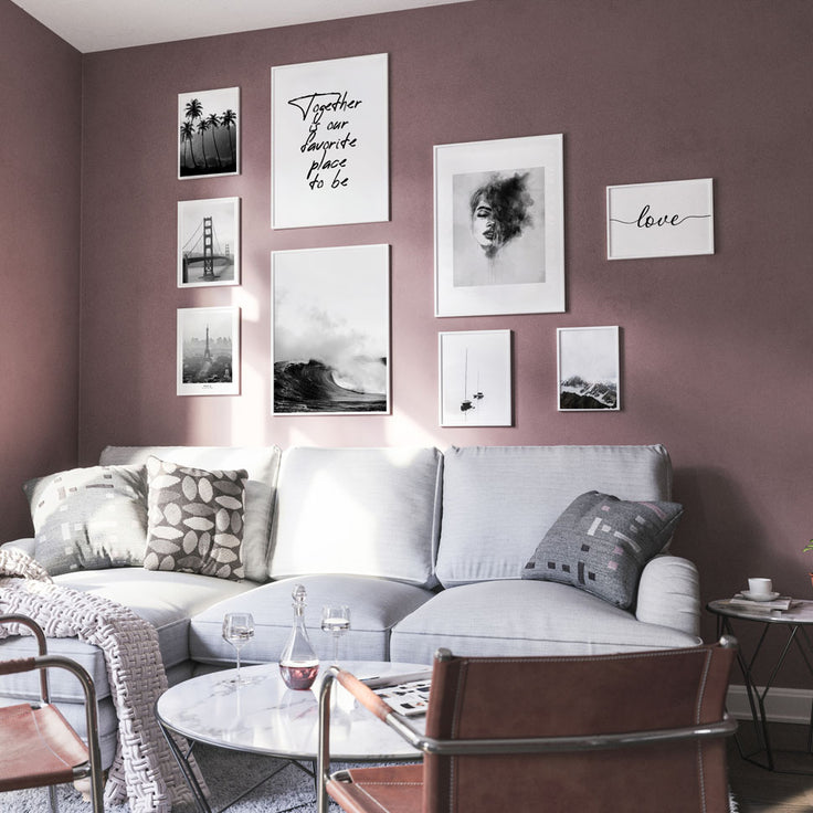 Bilderwand an bordeauxroter Wand im Wohnzimmer