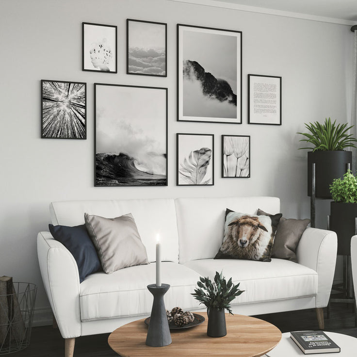 Schwarz-Weiß-Bilderwand über einem weißen Sofagruppe