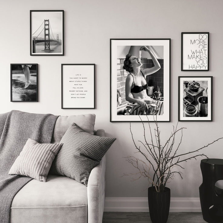 Stilvolle Schwarzweiss-Bilderwand nahe bei grauem Sofa.