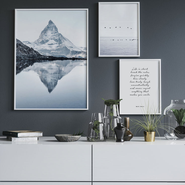 Winzige Bilderwand über weiße Kommoden auf dunkelgraue Wand